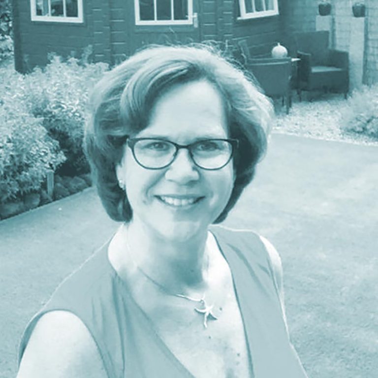 caroline Frau in Sportbekleidung mit Schmuck, lachend.