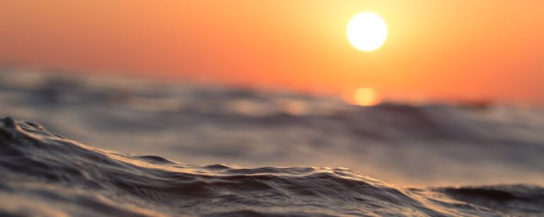 Sonnenuntergang über den Wellen, inspiriert zu aktiver Fitness und gesunder Ernährung.