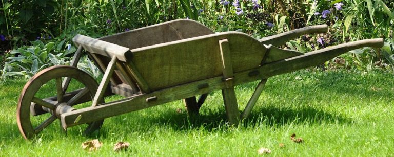 Holz-Schubkarre mit einem Rad auf grünem Rasen im Garten, ideal für Outdoor-Fitness.