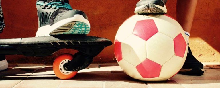 Fußballspieler auf einem Waveboard mit einem Fußball - gesunde Ernährung fördert sportliche Leistung.