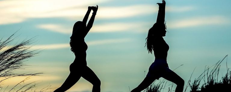 Zwei Frauen machen Yoga im Freien, um ihren gesunden Lebensstil zu fördern.