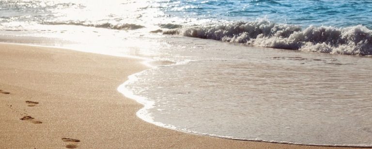 Fußspuren im Sand: ein Symbol für Fitnessziele und gesunde Ernährung.