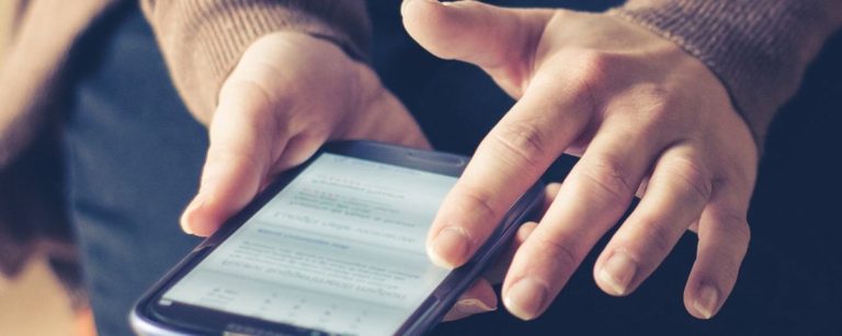 Person hält ein Smartphone mit Fitness-App in den Händen.