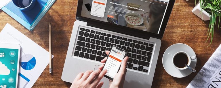 Ein Laptop und Smartphone zeigen die BenFit Lifestyle-App, die ein Ernährungs- und Fitnessprogramm anbietet.