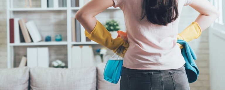 Frau mit Reinigungsmitteln bereit für den Frühjahrsputz im Fitnessstudio.