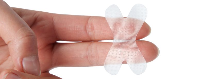 Close‑up of a roll of specialized sleep tape next to a calm bedside scene, illustrating the concept of mouth taping.