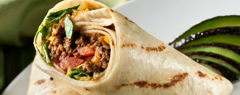 Healthy fast-food style wrap filled with seasoned minced beef, cheese, lettuce, tomato and onions
