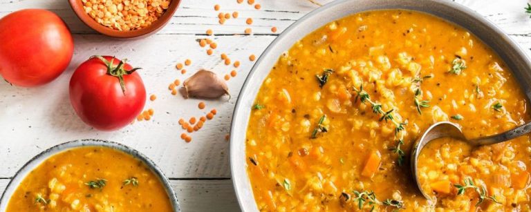 Warm bowl of hearty winter lentil soup with vegetables and herbs